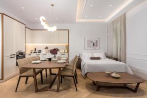 a room with a bed and a table and chairs at Plaza Apartments in Opatija