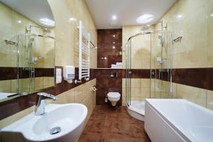 a bathroom with a sink and a shower and a toilet at Hotel Szyszko in Suwałki +40 photos