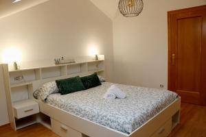 Habitación pequeña con cama y estanterías en ÁTICO DUPLEX CREDENCIAL, en Sarria
