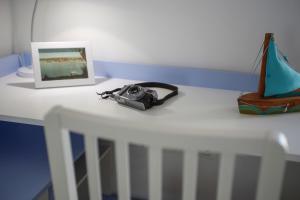 a camera on a table with a picture and a purse at Apartma Srčanka in Koper