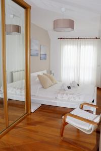 espejo en una habitación con cama y silla en ÁTICO DUPLEX CREDENCIAL, en Sarria
