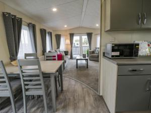a kitchen and living room with a table and a microwave at Happy Daze in Bridlington