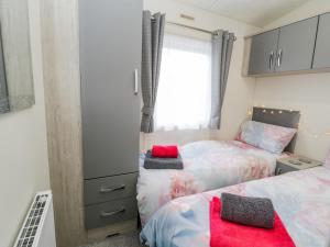 a bedroom with two beds and a window at Happy Daze in Bridlington