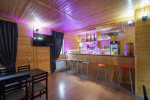 a bar with stools in a room with wooden walls at Everest Rest House in Tsaghkadzor