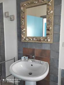 uma casa de banho com um lavatório e um espelho em la lampara em Favignana