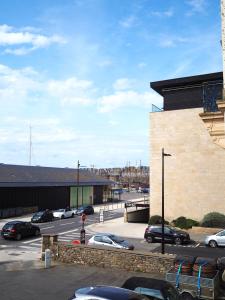 a parking lot with cars parked in front of a building at Le Bigorneau , beach at 20m and free private carpark in Saint Malo