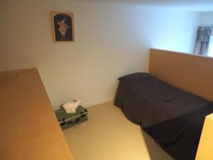 a small bedroom with a bed and a table at Le Bigorneau , beach at 20m and free private carpark in Saint Malo