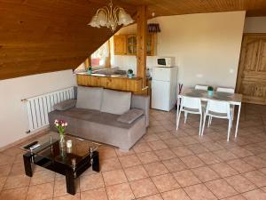 a living room with a couch and a table at Esther Apartman in Gyenesdiás