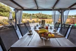 a wooden table with a bowl of fruit on it at Casa Del Miele, private pool, BBQ, mountain view. in Alikianós