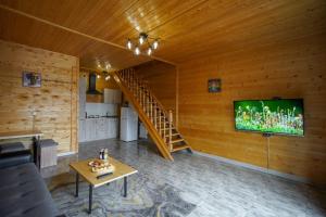 ein Wohnzimmer mit einem TV an einer Holzwand in der Unterkunft Everest Rest House in Zaghkadsor