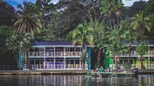 a group of people in a boat in front of a building at Tortuga Lodge & Gardens by Böëna in Tortuguero