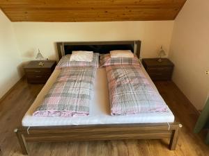 two beds in a bedroom with two night stands at Esther Apartman in Gyenesdiás