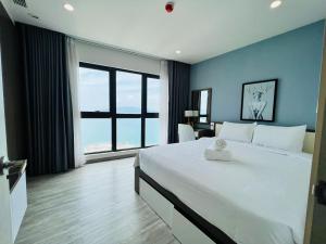 - une chambre avec un grand lit et une grande fenêtre dans l'établissement HighSea GoldCoast Superview Apartment, à Nha Trang