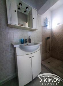 y baño con lavabo blanco y ducha. en Alopronoia Sunrise en Síkinos
