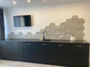 a kitchen with a black counter and a sink at Apartament 80’s in Kołobrzeg