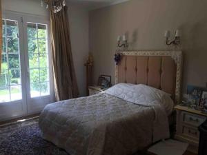 a bedroom with a large bed and a window at Villa Bonaparte in Touques