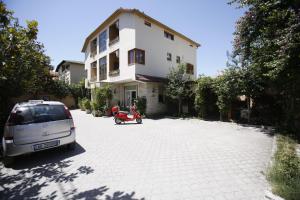 a car parked in front of a white building at Hotel Akropoli in Tirana