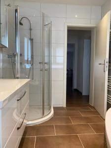 uma casa de banho com uma cabina de duche ao nível do chão e um lavatório. em Julias Ferienwohnung em Wetzlar