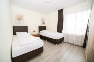 a room with two beds and a window at Othman Appartements Anderter Straße 55a 1OG in Hannover