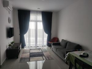 sala de estar con sofá y ventana grande en Heritage Homestay en Kota Tinggi