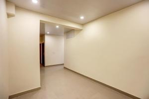 an empty hallway with white walls and tile floors at Collection O Sr Inn Awas Vikas in Kānpur