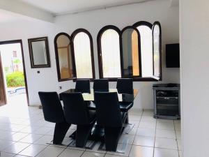 a dining room with a table and chairs and windows at Appartements Bahia Smir in Restinga Smir