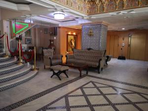 a living room with a couch and chairs and stairs at Majliss Hotel Downtown in Rabat