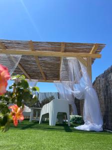 un pergolato con una panchina bianca in un cortile di Grano Arso Appartamento Turistico a Cisternino