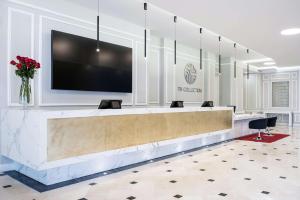 a lobby with a flat screen tv above a reception desk at NH Collection Plaza Santiago in Santiago
