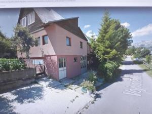 duży różowy dom z podjazdem przed nim w obiekcie Apartman Aleksandra w mieście Žabljak