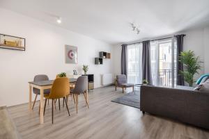 een woonkamer met een bank en een tafel en stoelen bij Szabolcs Apartments in Boedapest