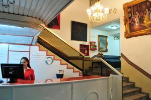 a woman sitting at a desk in front of a computer at Hotel Cordero in Cuenca