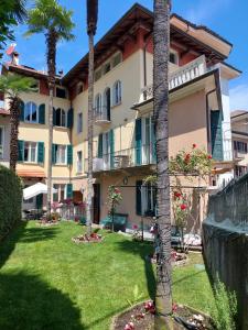 un gran edificio con palmeras en el patio en Casa Lari Stresa en Stresa