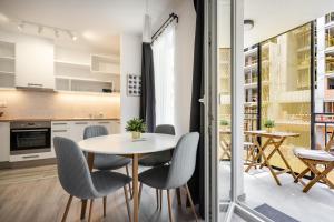 een keuken en eetkamer met een tafel en stoelen bij Szabolcs Apartments in Boedapest