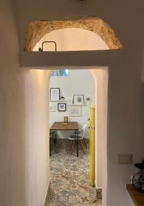 um corredor que leva a uma sala de jantar com uma mesa em Casa Stella Salento - grazioso appartamento con 2 camere da letto nel cuore di Galatone em Galatone