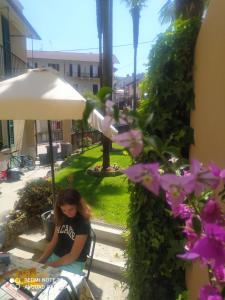 斯特雷薩的住宿－Casa Lari Stresa，坐在一把伞下椅子上的女人