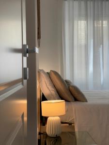 sypialnia z łóżkiem z poduszkami i oknem w obiekcie B&B Il Gabbiano w mieście Orbetello