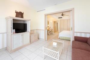 ein Wohnzimmer mit einem Sofa und einem TV in der Unterkunft Gran Castillo Tagoro Family & Fun Playa Blanca in Playa Blanca