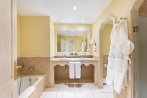 ein Badezimmer mit einer Badewanne, einem Waschbecken und einem Spiegel in der Unterkunft Gran Castillo Tagoro Family & Fun Playa Blanca in Playa Blanca
