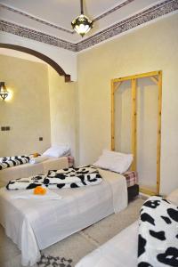 a room with two beds with cows on them at IMLIL VALLEY Garden in Imlil