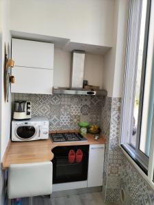 a small kitchen with a stove and a microwave at Casa Vacanze al mare in Pescara