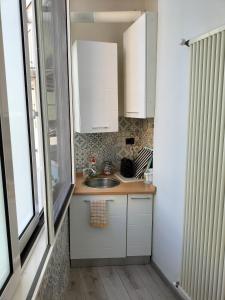 una pequeña cocina con fregadero y ventana en Casa Vacanze al mare, en Pescara