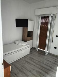Habitación blanca pequeña con cama y ventana en Casa Vacanze al mare, en Pescara