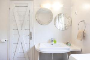 a white bathroom with a sink and mirrors at House Encanto in Veli Lošinj +50 photos