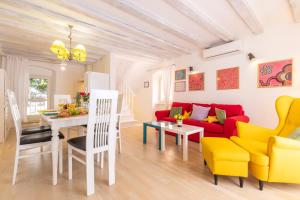 a living room with a red couch and yellow chairs at House Encanto in Veli Lošinj