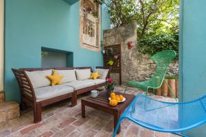 un patio con sofá, mesa y silla verde en House Encanto, en Veli Lošinj