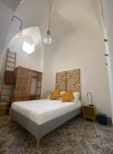 um quarto com uma cama com lençóis brancos e almofadas amarelas em Casa Stella Salento - grazioso appartamento con 2 camere da letto nel cuore di Galatone em Galatone