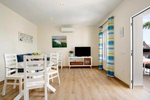 Casa Orilla Sur B في إل بلمار: غرفة معيشة مع طاولة وكراسي وتلفزيون