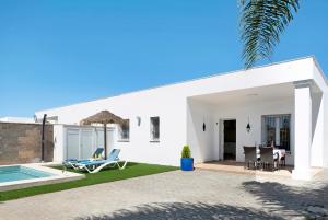 Cette maison blanche dispose d'une terrasse et d'une piscine. dans l'établissement Casa Orilla Sur B, à El Palmar