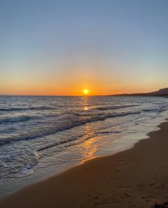 a sunset on a beach with the ocean at Accogliente Appartamento Costa Makauda in Ribera